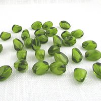 Olivine Czech glass givre beads are twisted ovals of translucent green pressed glass with opaque white inclusions. Beads measure approximately 13mm long and 9mm diameter, with 1mm lengthwise holes.