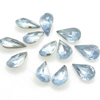 Vintage tin table cut pear shape rhinestones are translucent light sapphire blue backed with gold foil. Point back stones measure 13mm long and 7.8mm wide.