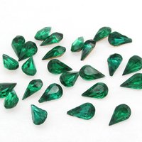 Vintage tin table cut pear shape rhinestones are translucent emerald green backed with gold foil. Point back stones measure 10mm long and 6mm wide.