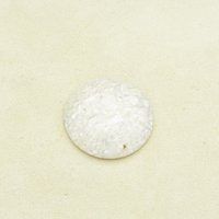 Opaque beige jasper cabochon is polished on both sides, with a domed top. Stone has mottled look, with lighter patches of cream and some small translucent areas. Low dome cabochon measures approximately 30mm across and 6mm thick at the center. 