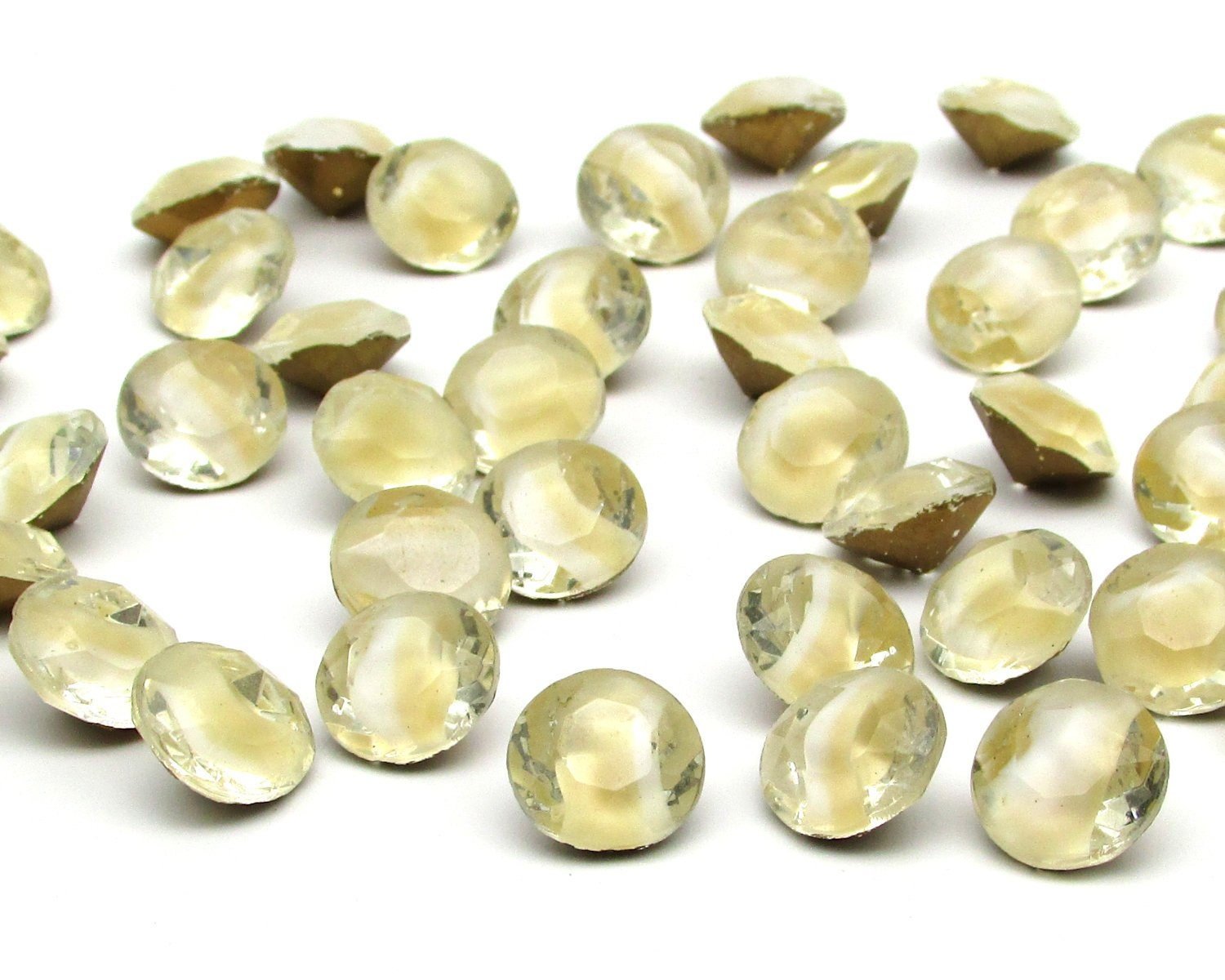 48ss (approximately 11.5mm) dentelles have two-tone beige and white opaque givre in clear faceted rhinestones. Table cut glass gems have pointed backs with gold foil.