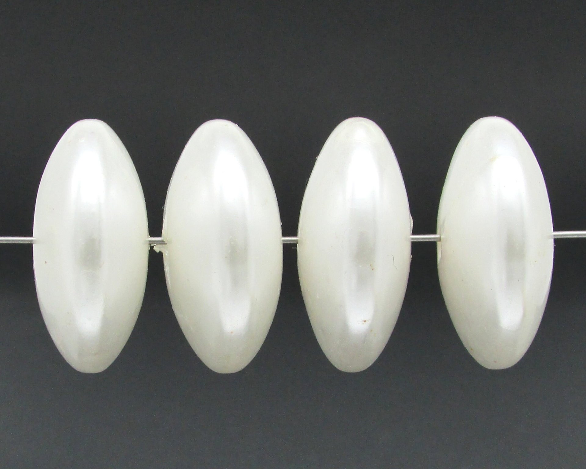 Vintage white plastic saucer beads measure approximately 26.5mm diameter and 12mm hole-to-hole. Large, pearlized rondelles have a 2mm diameter center hole.