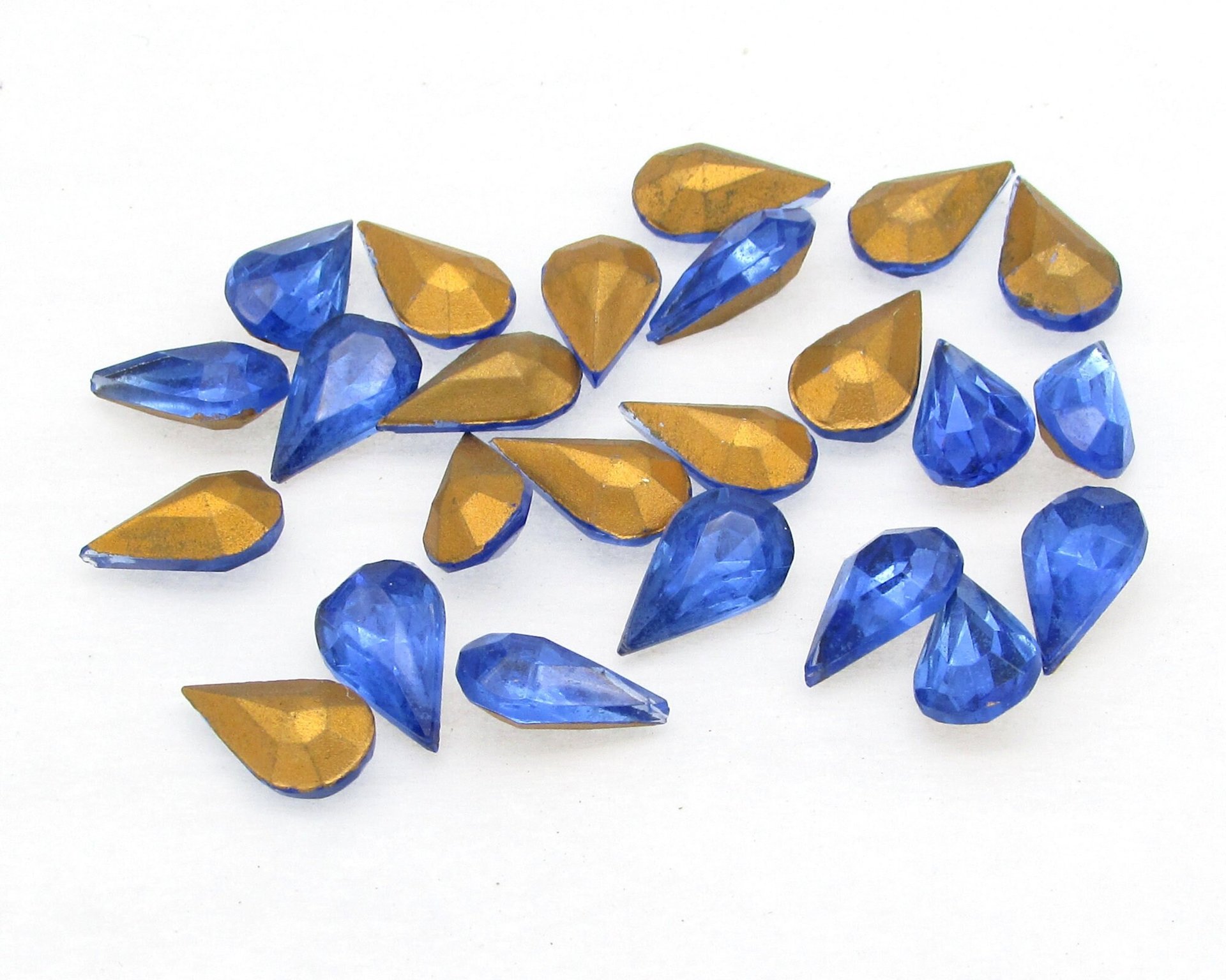 Faceted pear shape rhinestones are translucent sapphire blue with gold foil. Vintage tin table cut glass gems measure 10mm long and 6mm wide, with pointed backs. 