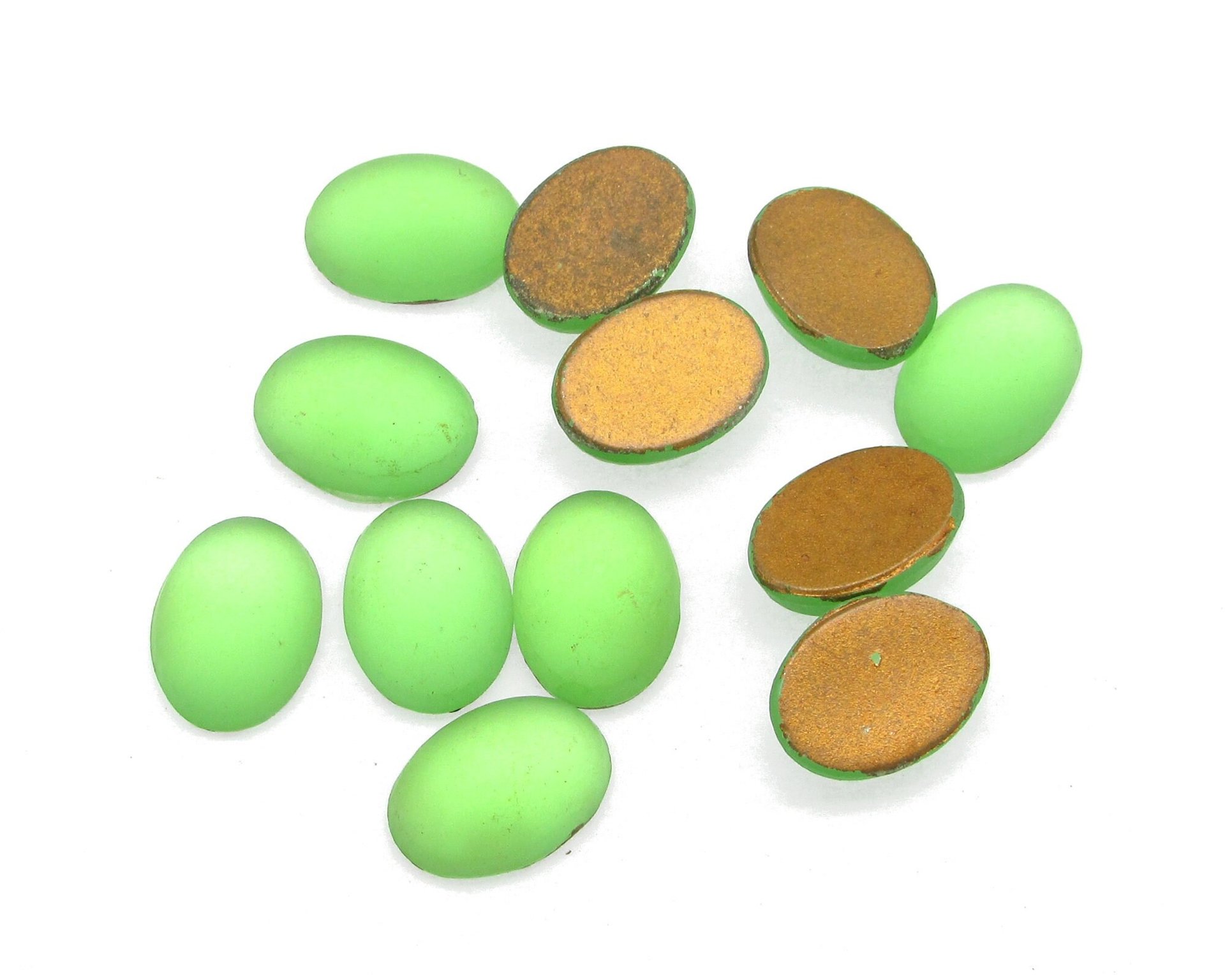 14x10mm vintage glass cabochons are matte peridot green. Smooth flat back gems have a 5mm dome and gold foiled backs.