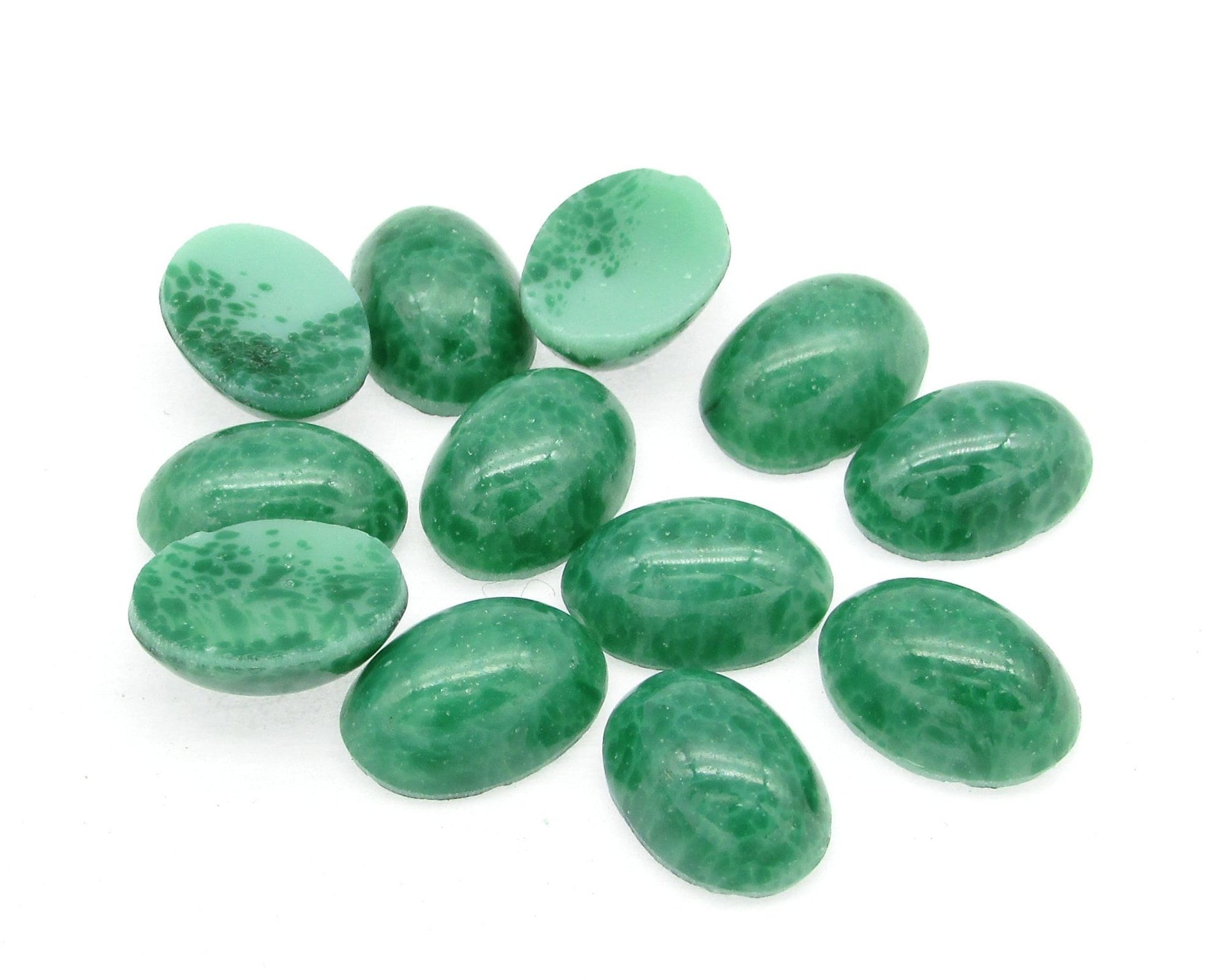 14x10mm vintage glass cabochons are opaque green faux jade matrix, meant to mimic natural stone. Smooth flat back gems have a 5mm dome and unfoiled backs.