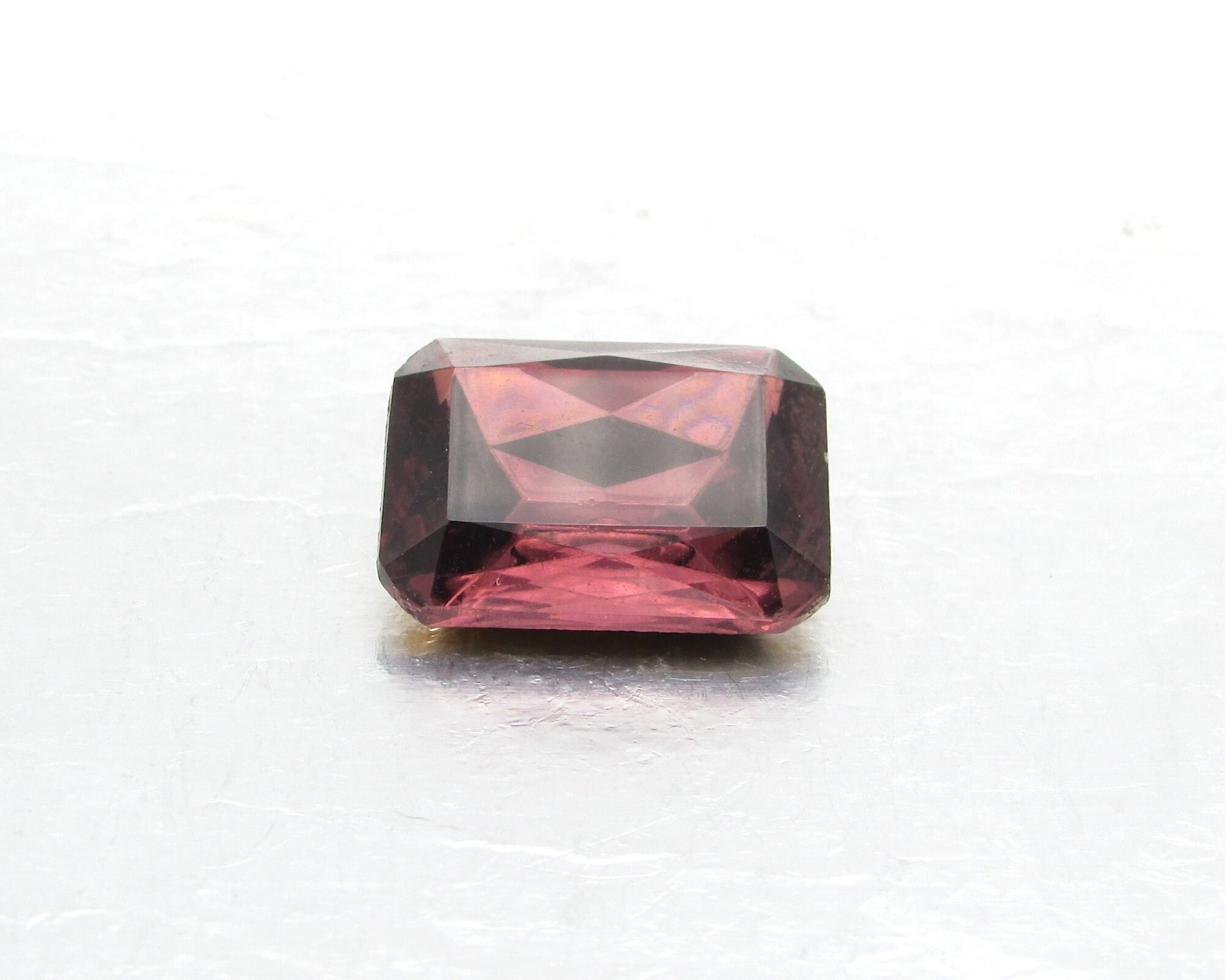 Vintage baguette rhinestone is a faceted octagon measuring 20mm long, 15.5mm wide, and 7.5mm thick at the center. Amethyst purple table cut glass has a pointed back and gold foiling.