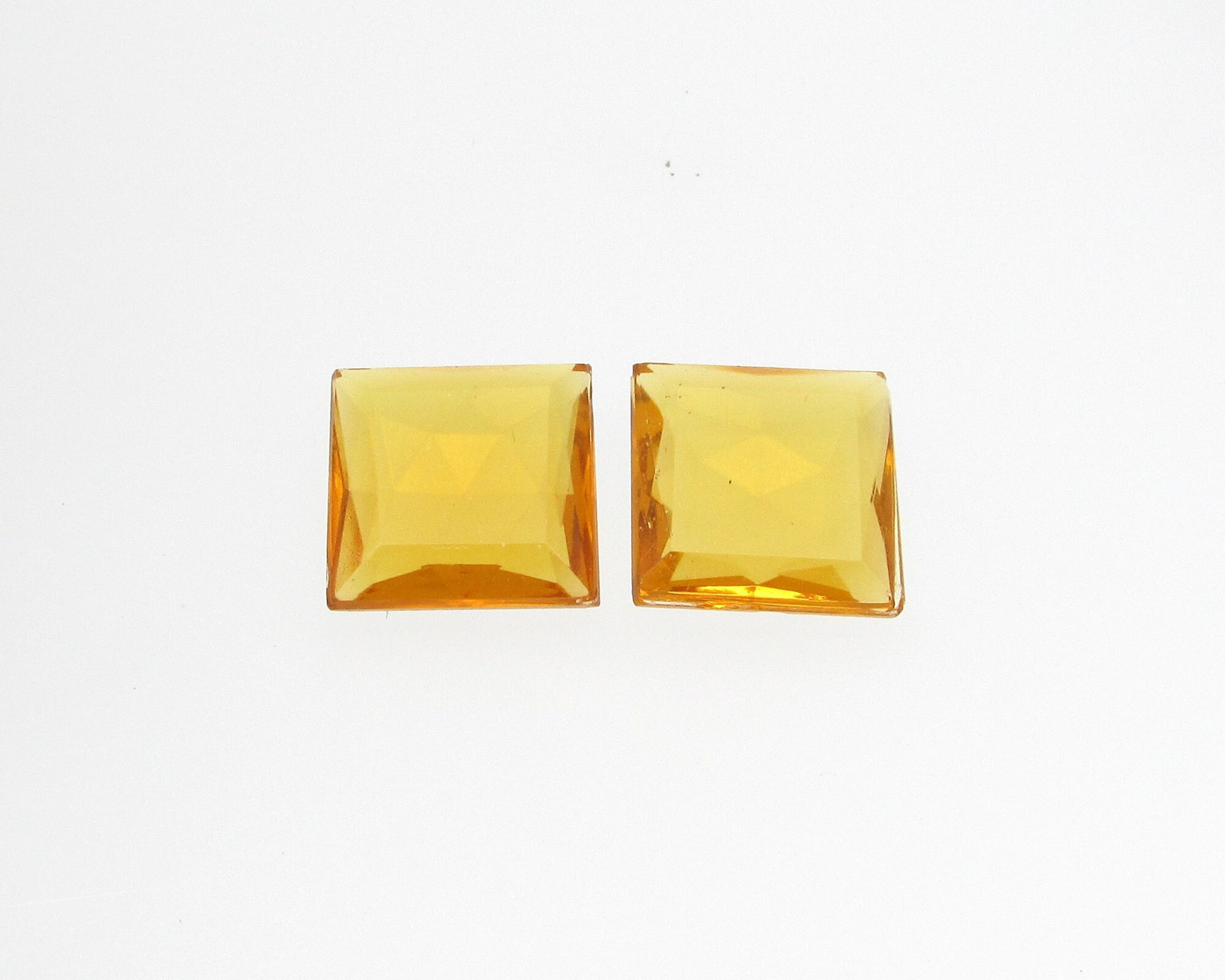 Unfoiled topaz rhinestones are tin table cut glass stones with a faceted back and a flat top table with beveled edges. Stones measure approximately 14.5mm square and 5mm thick at the center. 