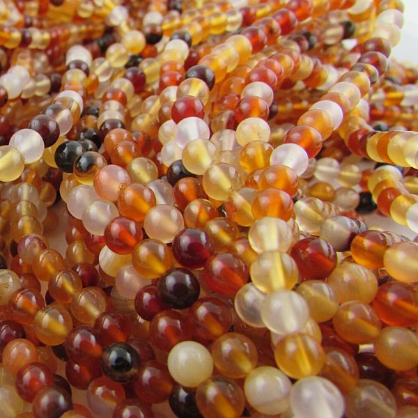4mm round gemstone beads are smoothly polished carnelian gemstone  spacer beads on a 16 inch strand of about 100 beads. Each strand has a mix of orange and brown shades.