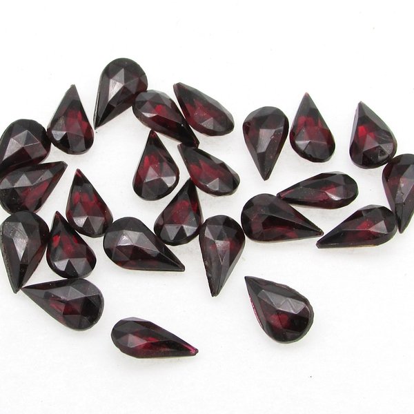 Vintage tin table cut pear shape rhinestones are translucent garnet red backed with gold foil. Point back stones measure 10mm long and 6mm wide.