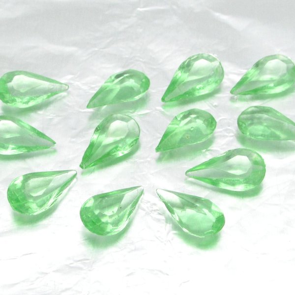 Vintage tin table cut pear shape rhinestones are translucent pastel green. Unfoiled point back stones measure 14mm long and 8mm wide.