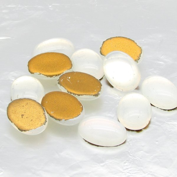 Vintage glass cabochons are semi-translucent opaline white with gold foil. Flat back gems measure 14mm long by 10mm wide, with a smooth 5mm dome. 