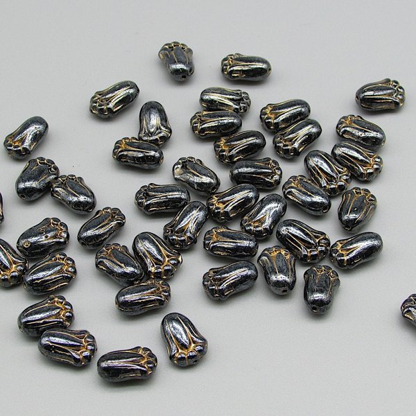 Opaque dark gray tulip-shaped pressed glass beads measure 12mm long, 8mm wide, 5.5mm thick. Center drilled lengthwise holes have an approximate diameter of 0.8mm. Beads are a shiny dark gray with a gold wash that highlights the details.
