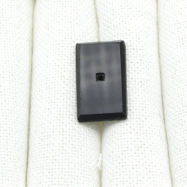 Rectangular glass stone has a flat table and a faceted back. Opaque black gem has an empty square beveled setting in the center to hold a tiny square rhinestone (sold separately).