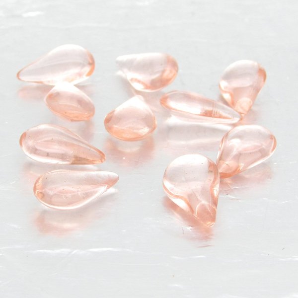 Vintage glass teardrop cabochons are translucent pale pink. Pressed glass stones measure 12.8mm long, 7.8mm wide, and  4.5mm thick at the center. The unfoiled backs come to a soft point.