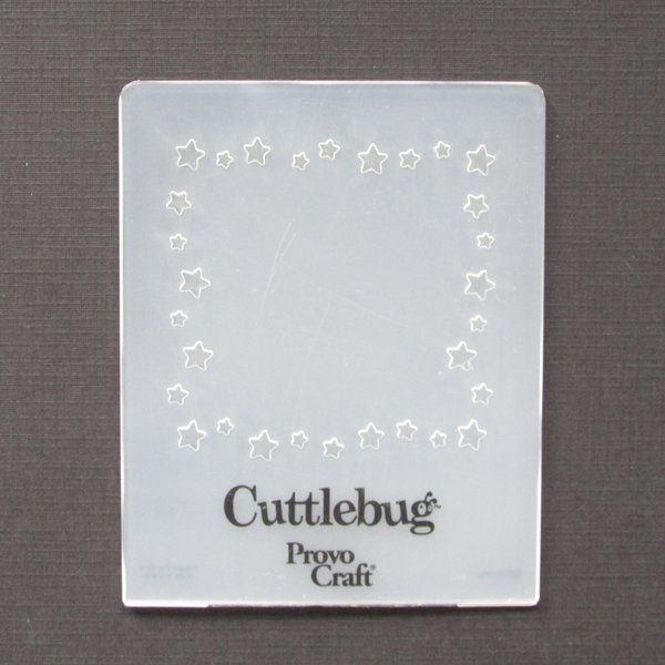 Cuttlebug embossing folder is flexible plastic with a whimsical star pattern for surrounding a square die-cut, photo, or text. Folder measures approximately 3.75 inches by 3 inches.