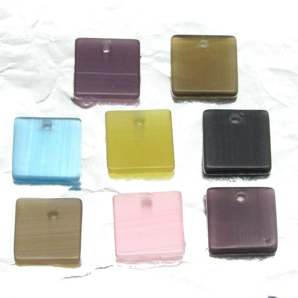 Flat square fiber optic glass pendant beads measure 12mm on each side and approximately 2.5mm thick. Front-drilled hole is approximately 1mm in diameter and slightly off center. 