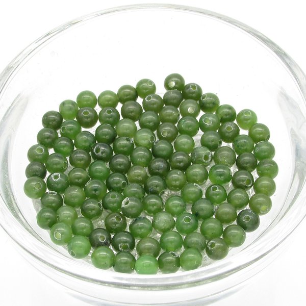 Nephrite jade round beads are deep olive green beads with center-drilled holes. Nephrite is a naturally occurring mineral; translucently, color, and inclusions vary from bead to bead. Available sizes: 4mm, 8mm and 10mm.