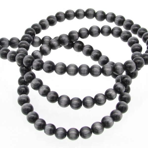 Black 4mm cat's eye glass beads are smooth spheres with center-drilled 0.51mm holes (24 gauge wire passes through easily). The cats eye effect is the result of fiber optic refraction in the glass. 